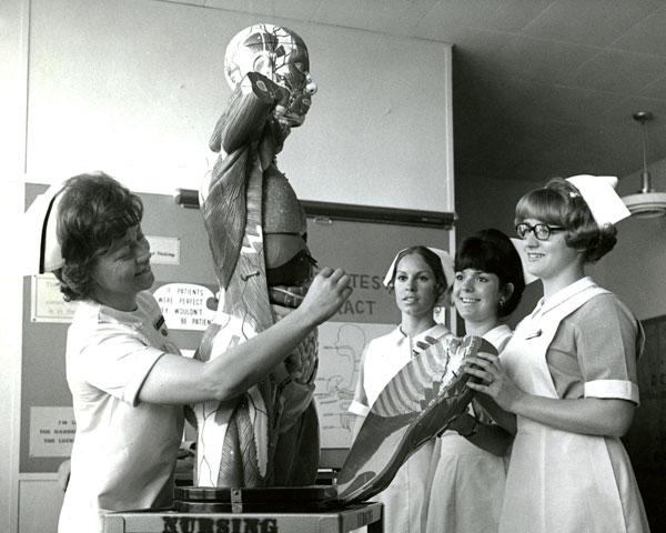 Nurses studying a human body anatomical model