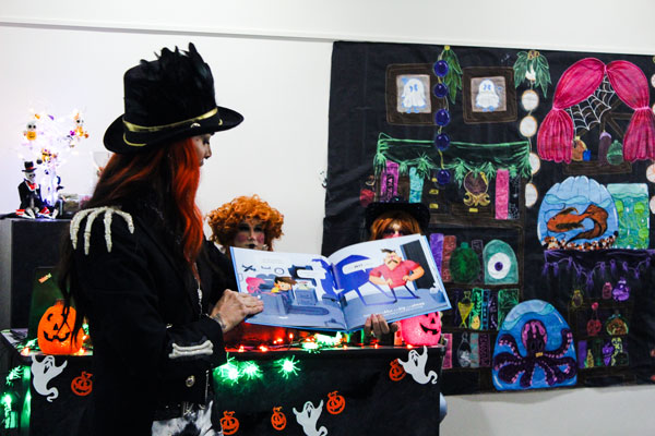 Person dressed up for Halloween reading a storybook